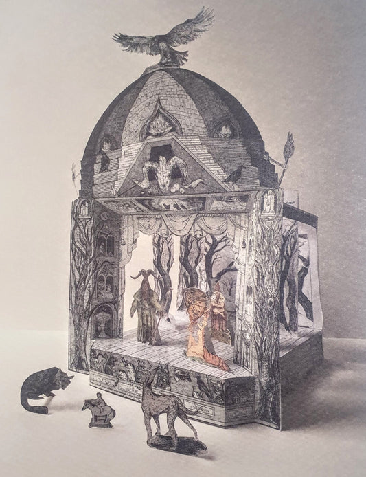 A three-dimensional paper toy theatre featuring a gothic-style magical show scene, with a bird perched on the roof, and various magical characters, perhaps sorcerers or witches, on the stage. Further small figures and animals stand in the foreground in front of the theatre.